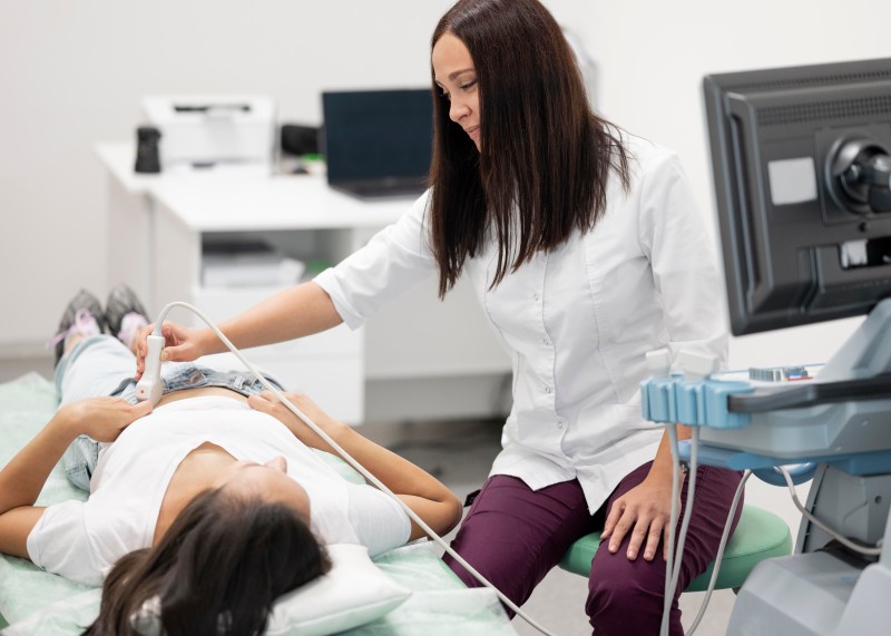 Healthcare professional performing an ultrasound examination on a patient in a clinical setting, illustrating Abortion services and reproductive healthcare